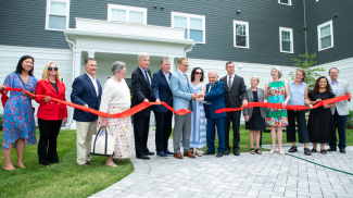 Ribbon cutting event outside of new housing complex