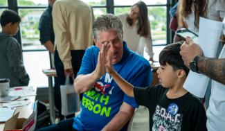 Governor McKee and a student doing a "high five"