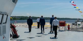 Governor McKee and staff approaching a helicopter landing pad