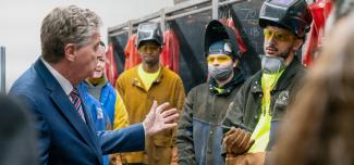 Governor McKee talking with a group of welders